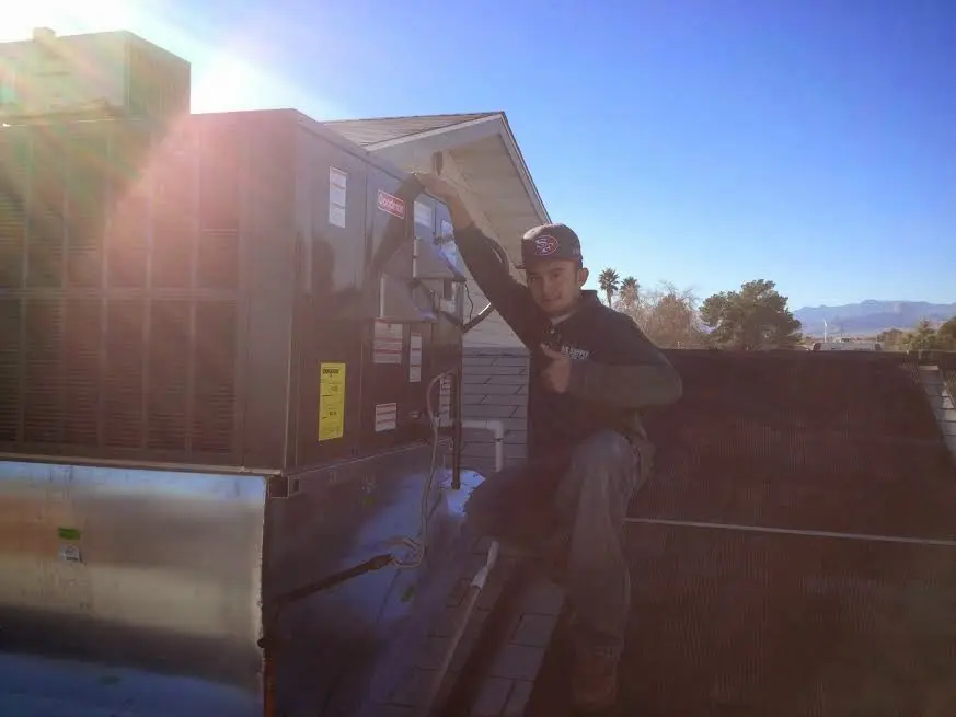 HVAC technician performing Heat Pump Repair on a rooftop unit in Farmville